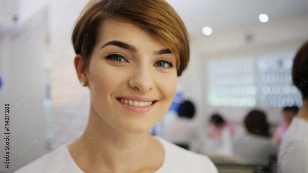 Attractivesmiling woman applying make up to her face with a brush looking at camera. Attractivesmiling woman applying make up to her face with a brush looking at camera.