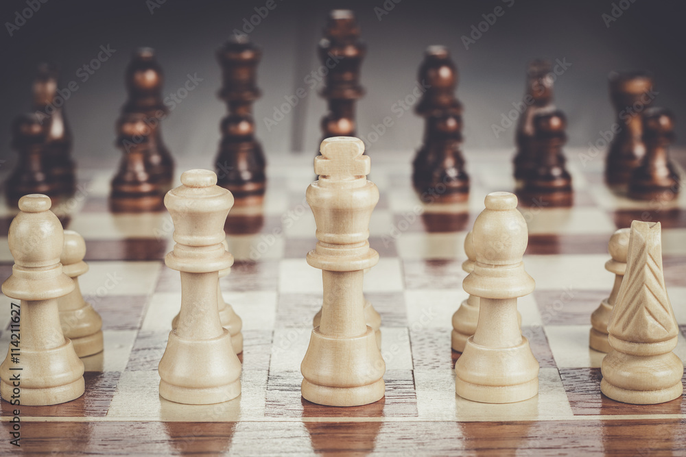 chess board with figures on the brown wooden table background chess board with figures on the brown wooden table background