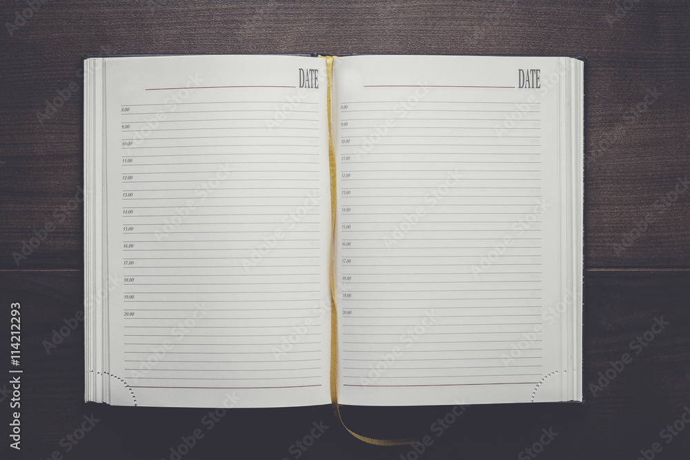 opened notebook on the brown wooden table opened notebook on the brown wooden table