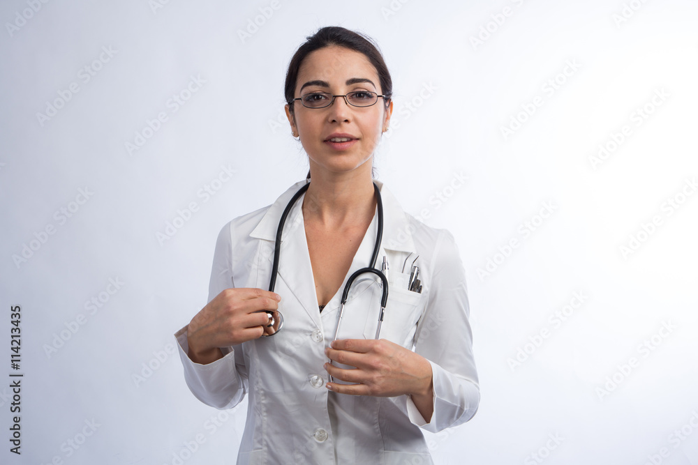 Medico donna su sfondo chiaro si prepara ad usare lo stetoscopio. 