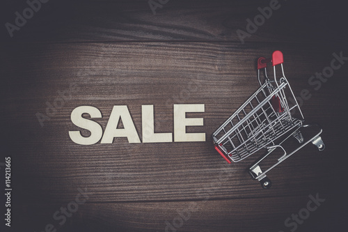 sale concept on the wooden background. shopping trolley