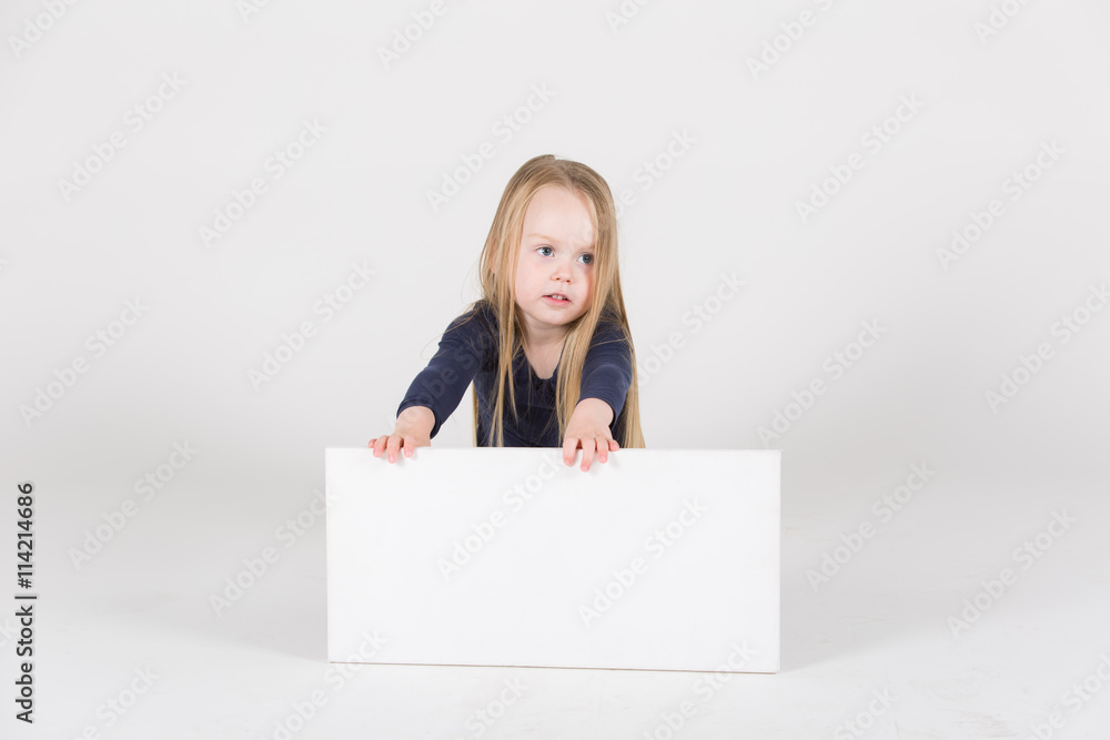 junges Mädchen sitzt vor Schild und interagiert damit junges Mädchen sitzt vor Schild und interagiert damit