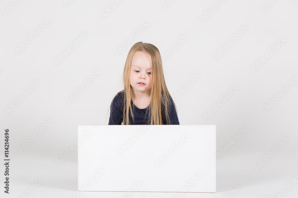 junges Mädchen sitzt vor Schild und interagiert damit junges Mädchen sitzt vor Schild und interagiert damit
