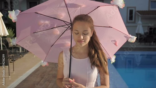 Young girl walking under an umbrella photo