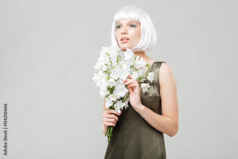Pensive beautiful young woman with bouquet of flowers Pensive beautiful young woman with bouquet of flowers