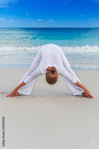 Woman practices yoga on the tropical beach