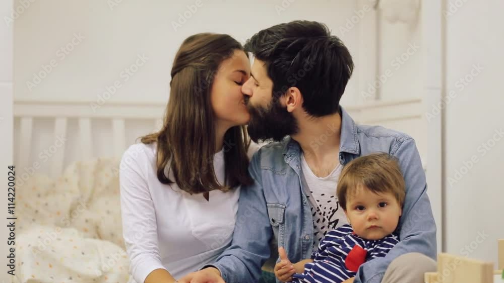 Happy family mother and father playing with a baby at home Happy family mother and father playing with a baby at home