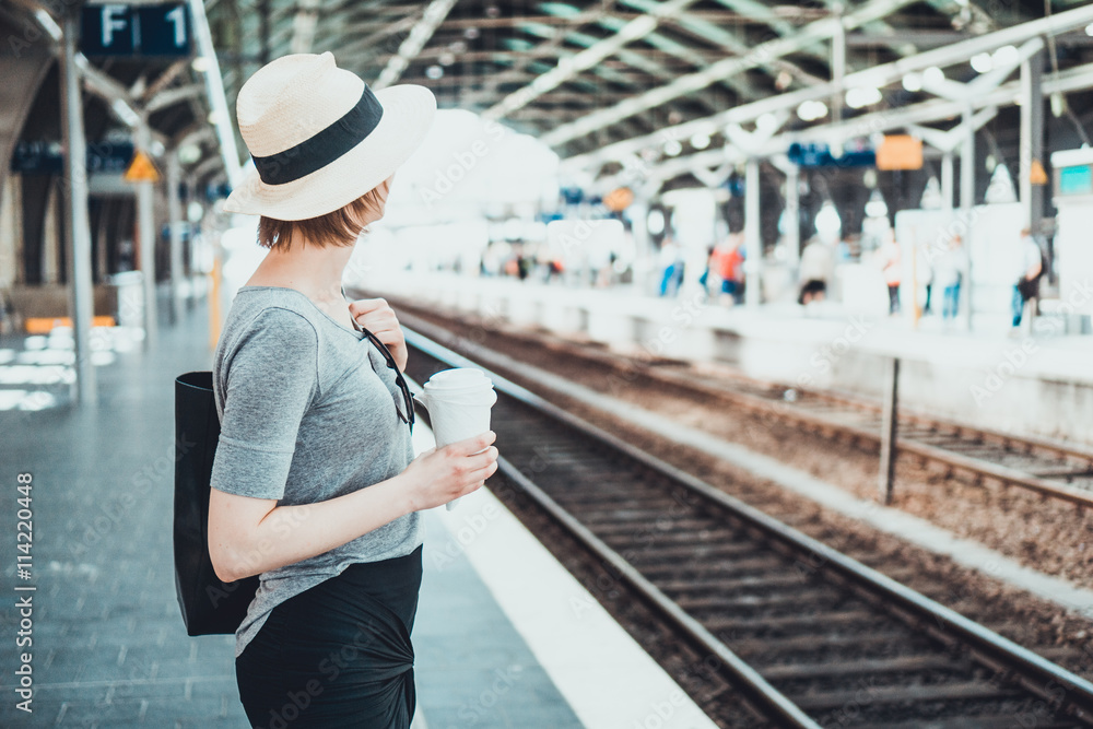 Woman looking away down track at station
