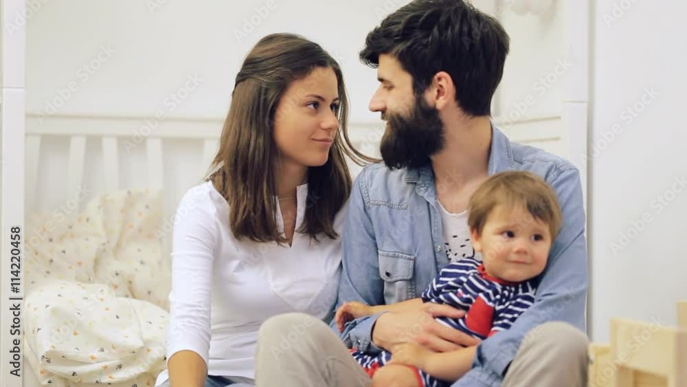 Happy family mother and father playing with a baby at home Happy family mother and father playing with a baby at home
