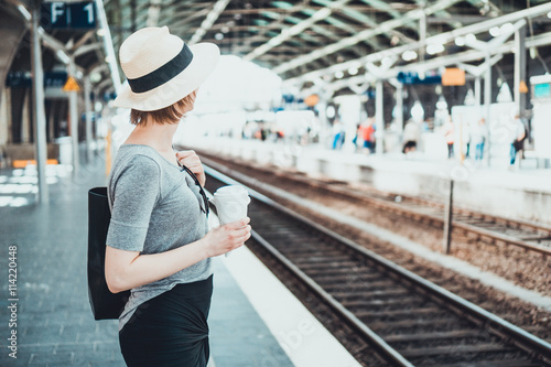 Woman looking away down track at station