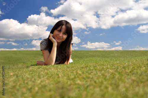 Obraz na płótnie Happy girl lying on the grass against the sky w salonie