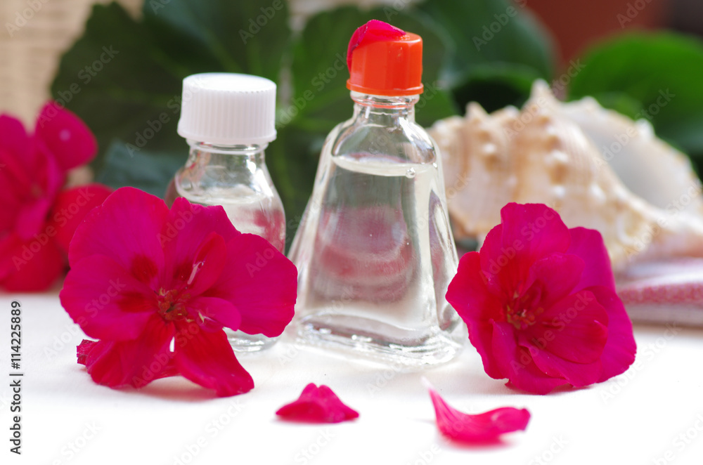 Essential geranium oil on the wooden background Essential geranium oil on the wooden background