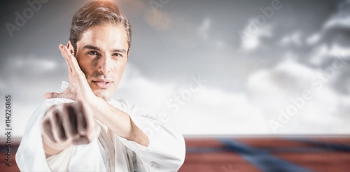 Composite image of portrait of fighter performing karate stance