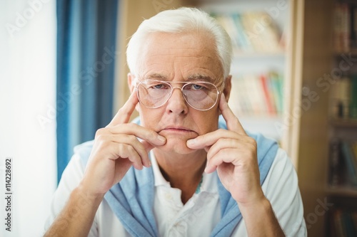 Sad senior man sitting at table