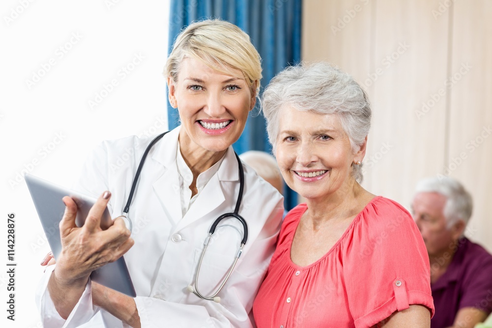 Smiling senior woman and nurse holding a tablet Smiling senior woman and nurse holding a tablet