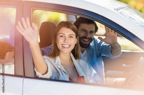 Happy couple waving hands while in car © WavebreakmediaMicro
