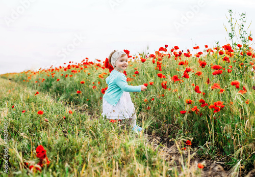 little girl having fun in poppy field