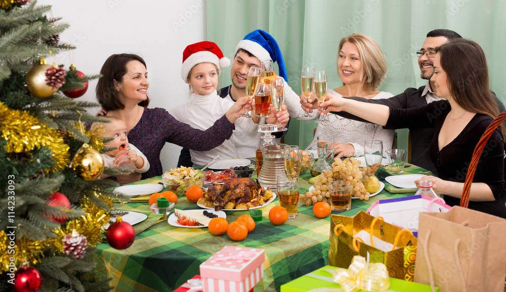 Relatives joyfully celebrate Christmas at table o