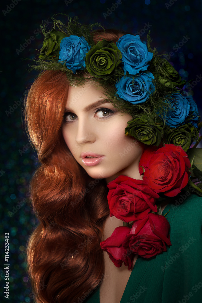 Beautiful model woman with blue, green and redrose flower in hai