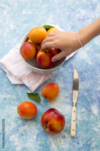 Hand of girl taking nectarine photo