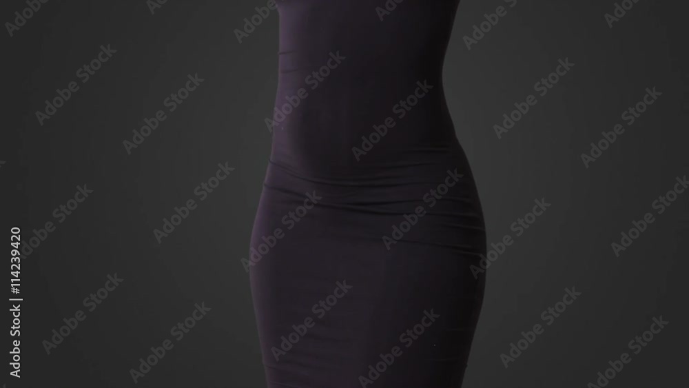 Sexy woman in tight black dress dancing on grey background. Close up of butt as woman turns around. Sexy woman in tight black dress dancing on grey background. Close up of butt as woman turns around.