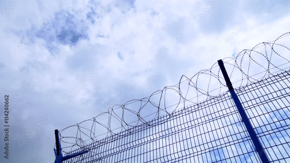 Timelapse of clouds and blue sky over barbed wire Timelapse of clouds and blue sky over barbed wire
