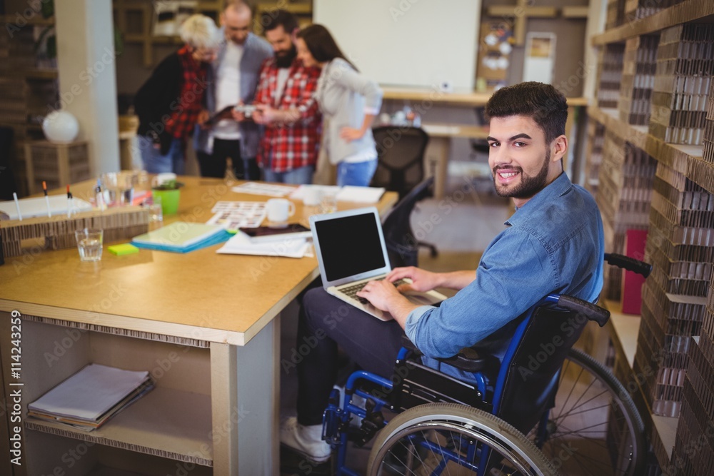 Obraz premium Confident disabled businessman using laptop at desk 
