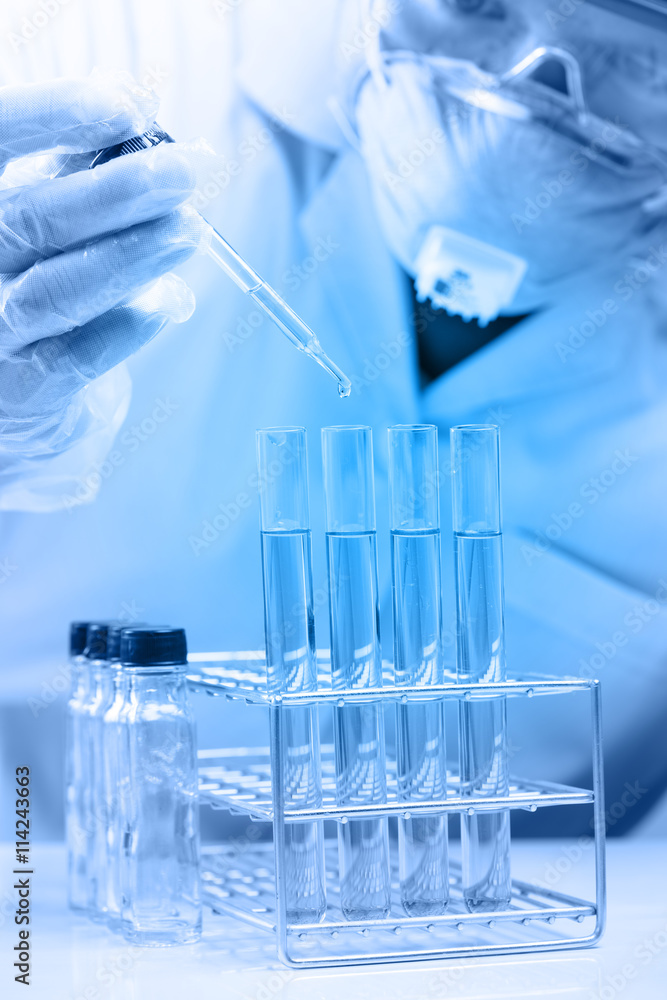 scientist dropping chemical liquid to flask with lab glassware scientist dropping chemical liquid to flask with lab glassware