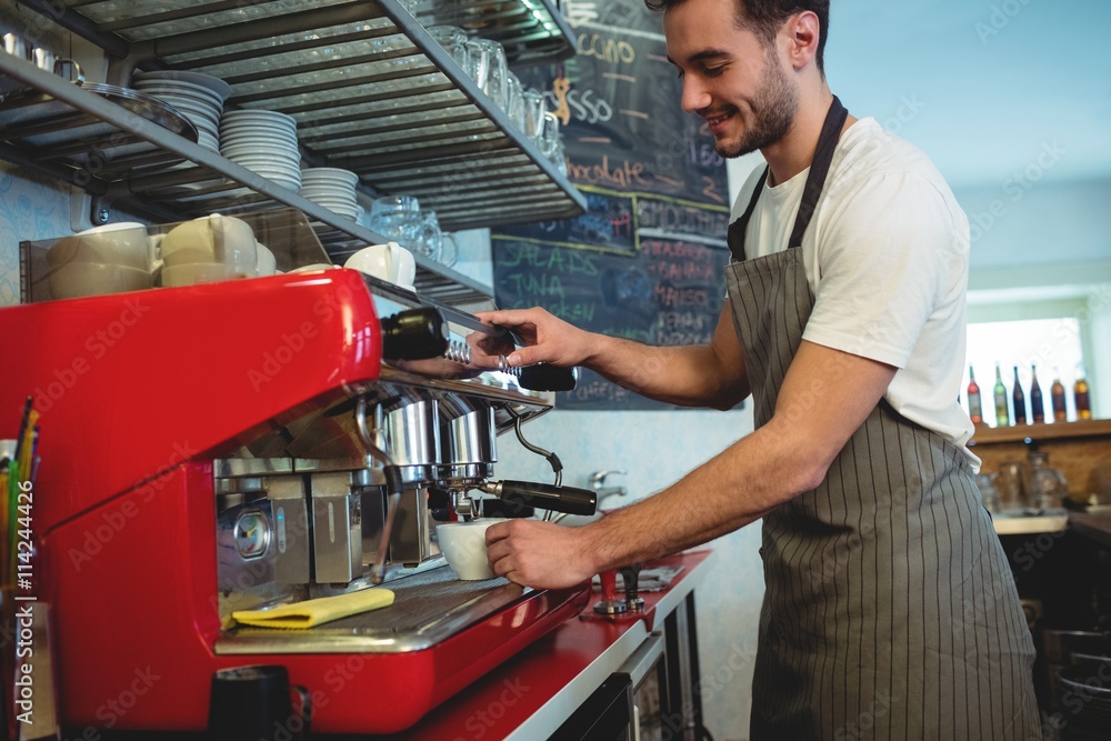 Happy barista using coffee maker at cafe Happy barista using coffee maker at cafe