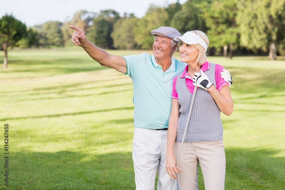 Golfer man pointing while standing by woman Golfer man pointing while standing by woman