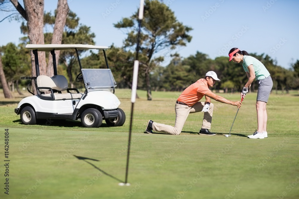 Obraz premium Man teaching woman playing golf