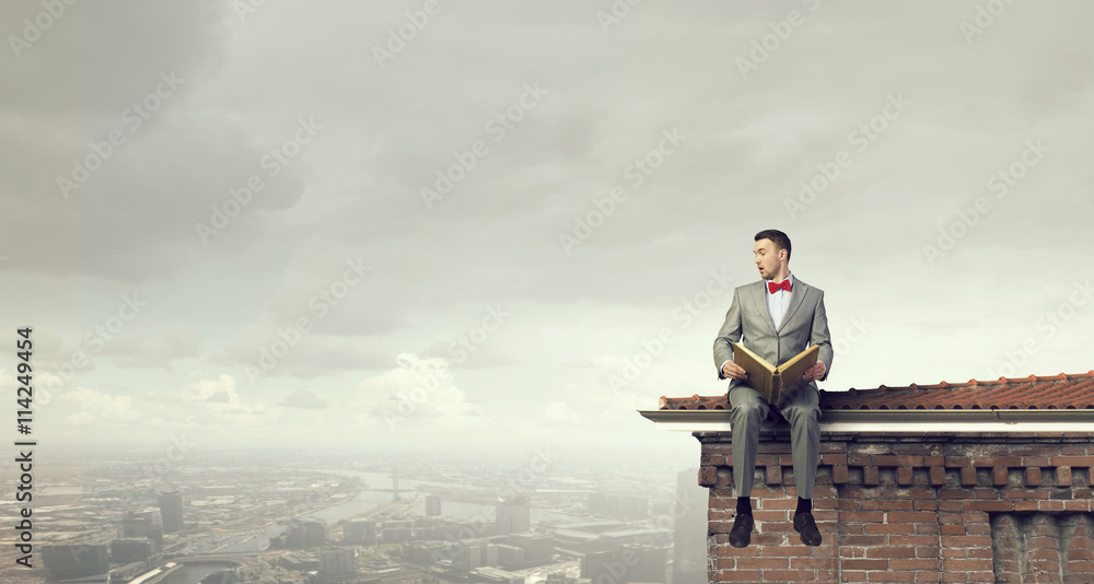 Businessman reading old book . Mixed media Businessman reading old book . Mixed media