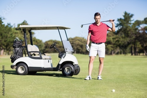 Handsome young man carrying golf club
