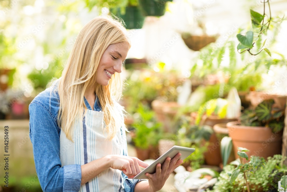 Female gardener using digital tablet at greenhouse Female gardener using digital tablet at greenhouse
