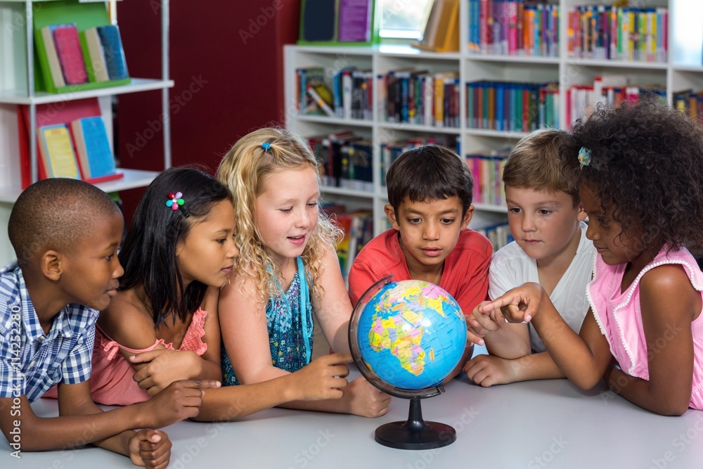 Fototapeta premium Children looking at globe on table