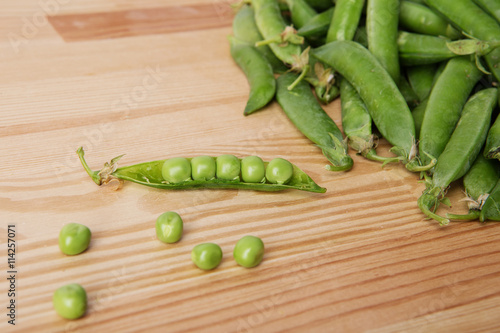 green peas in pods freshly picked on wood.