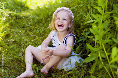Canvas-taulu Very happy little girl laughing in grass