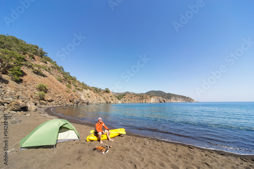 Men travel by canoe on the sea in the summer.