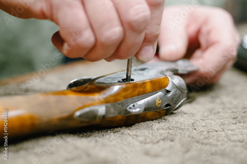 Close up of hands repairing gun