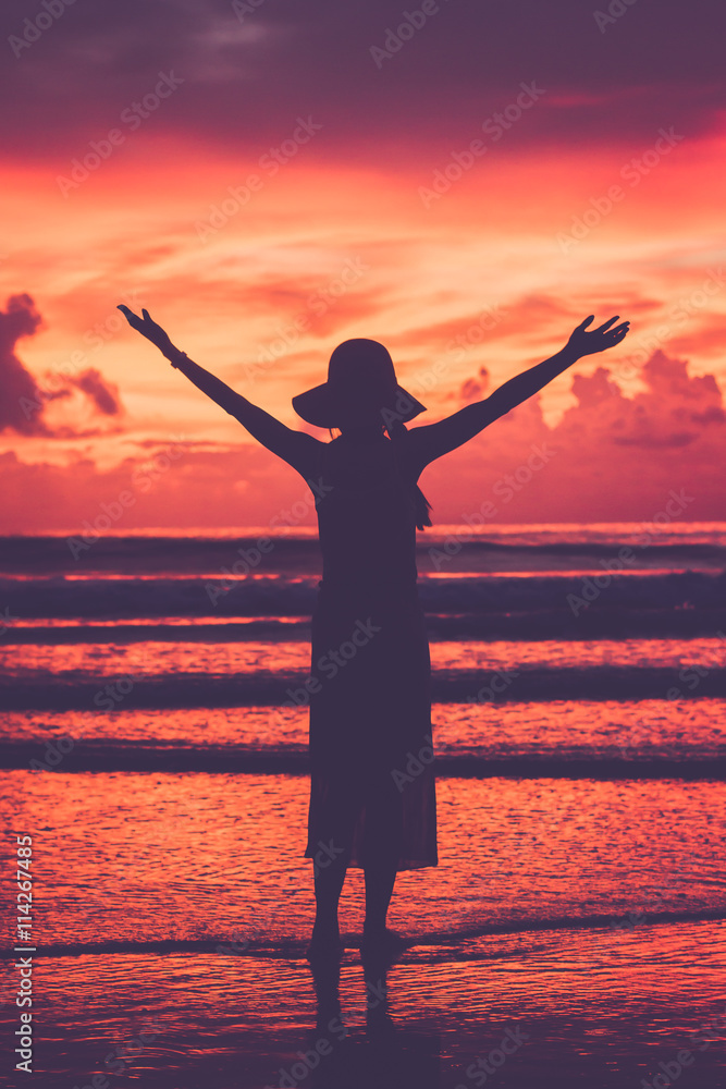 Silhouette woman on sea and beach in sunset time