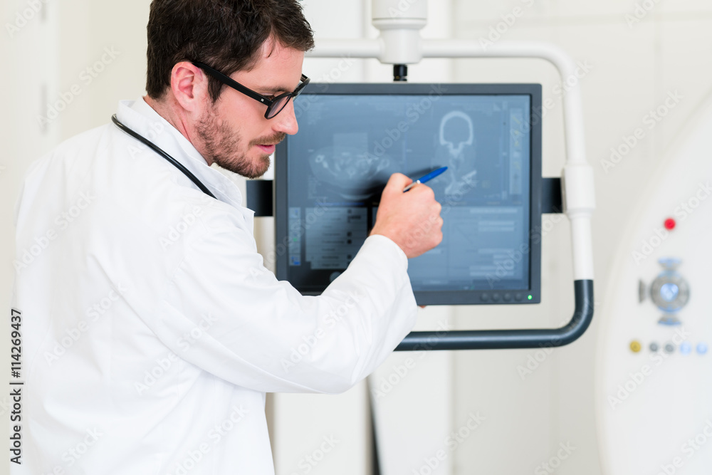 Arzt im Krankenhaus erklärt Bild einer MRT Tomographie auf Bildschirm