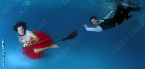 The witch flying on a broom under the water and drags man to las photo