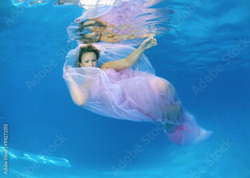  Woman presenting underwater fashion in pool