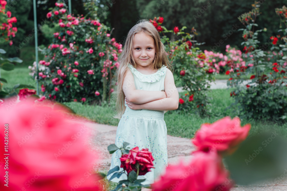 Beautiful little girl in the blooming garden  