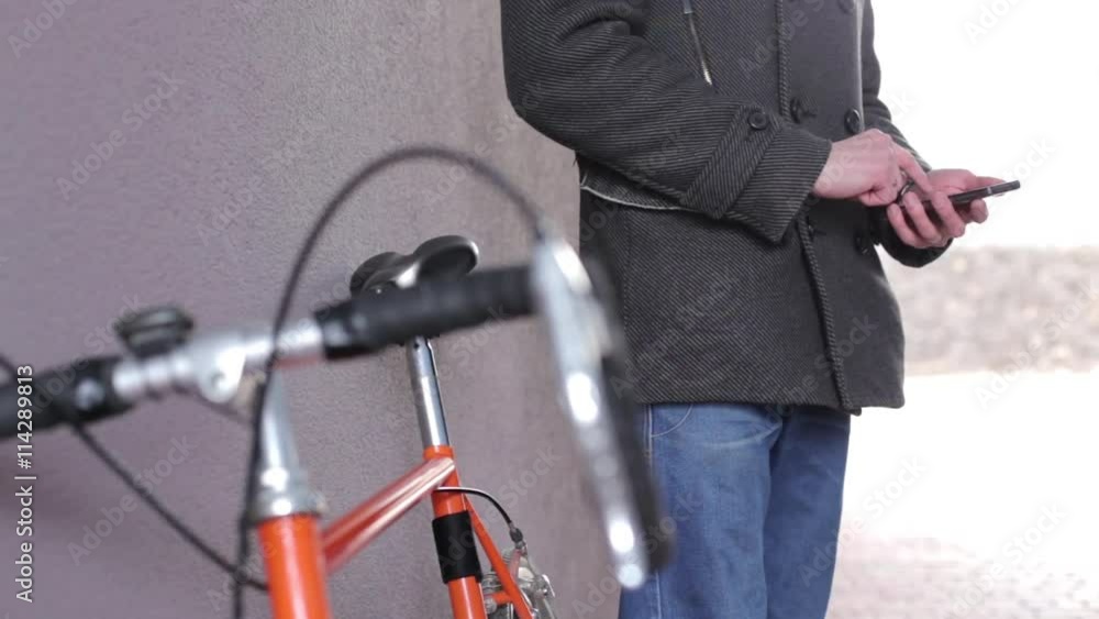 Cyclist writes sms on phone Cyclist writes sms on phone