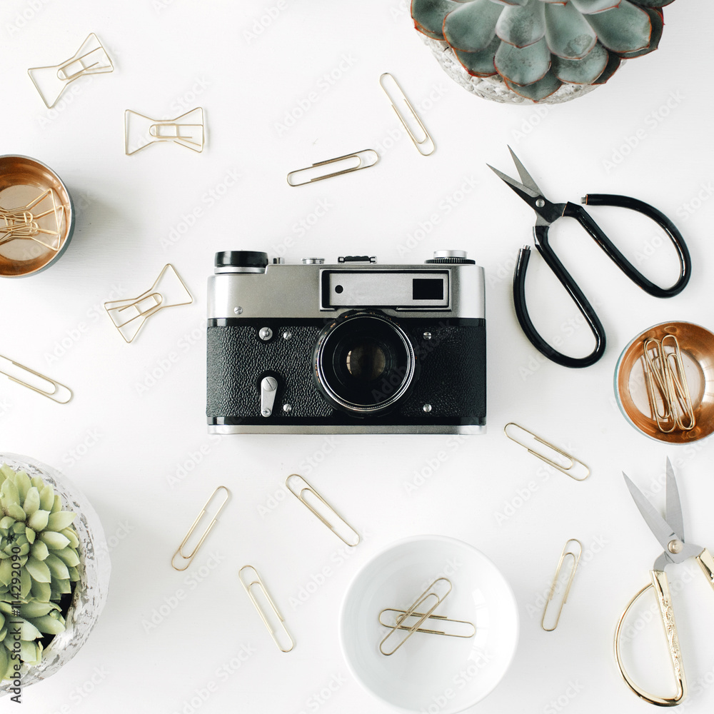 feminini desk workspace with succulent, retro camera, scissors and golden clips on white background. flat lay, top view feminini desk workspace with succulent, retro camera, scissors and golden clips on white background. flat lay, top view