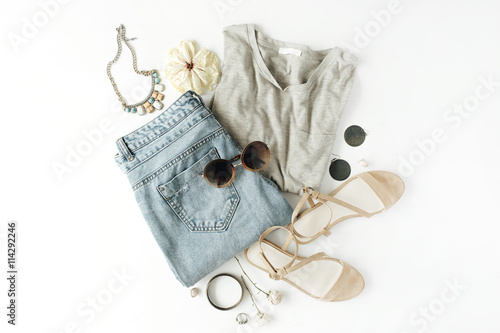 flat lay feminini clothes and accessories collage with shirt, jeans shorts, sunglasses, bracelet, sandals, earrings on white background. photo