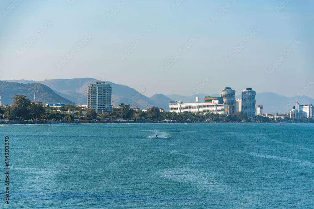 Boat moving on the sea with cityscape on the background. Hua Hin, Thailand