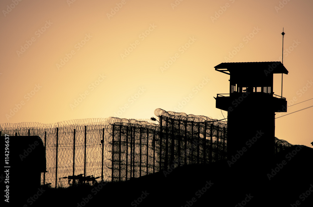 Silhouette of barbed wires and watchtower of prison in Neapolis, Crete