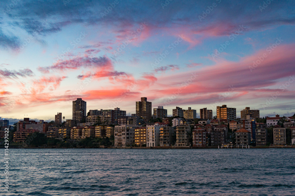 Cityscape with dramatic colorful evening sky on the background. Modern buildings of Kirribilli suburb of North Sydney, Australia. Urban sunset landscape with space for text